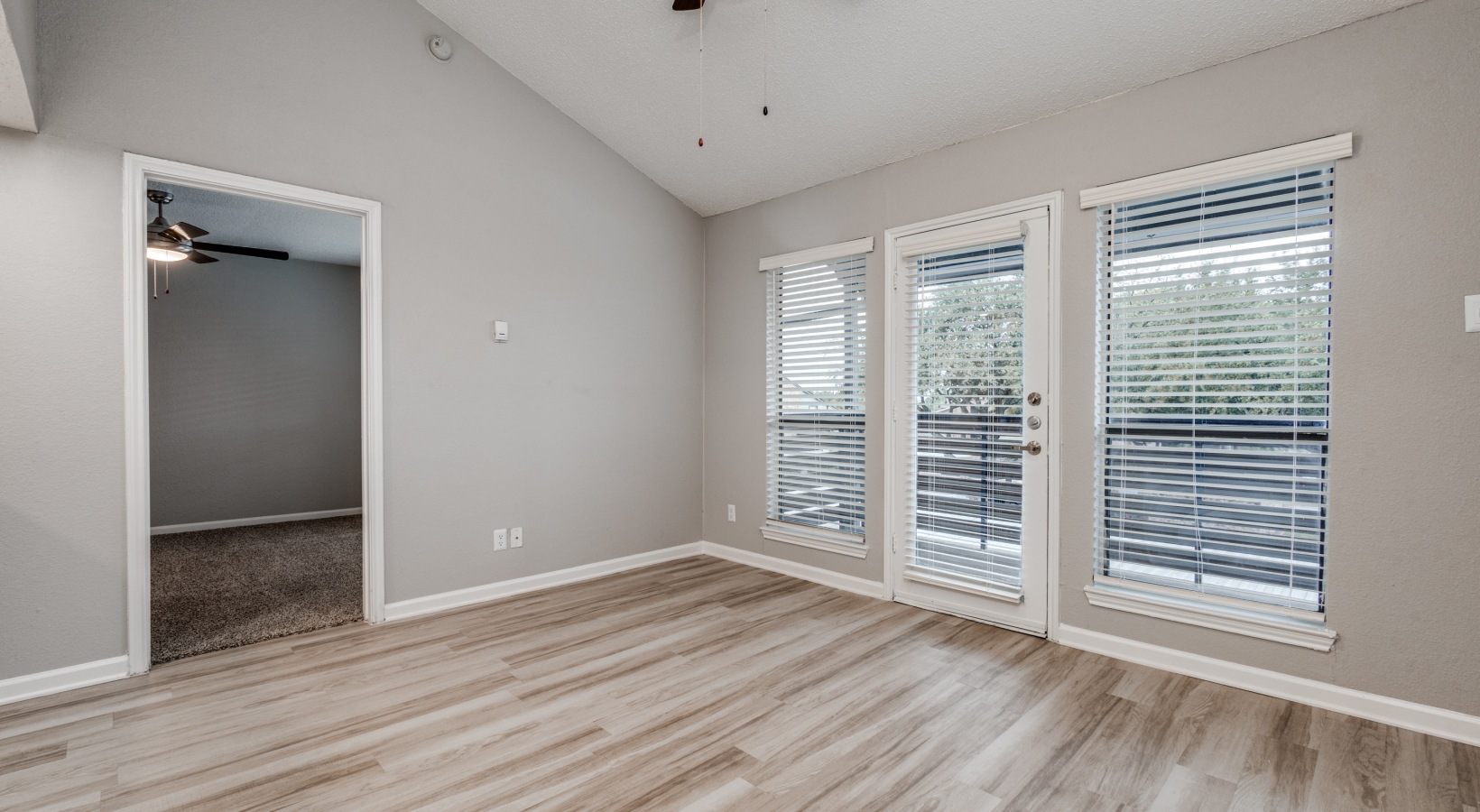 empty room with hardwood floors and sliding glass doors at The Wilder