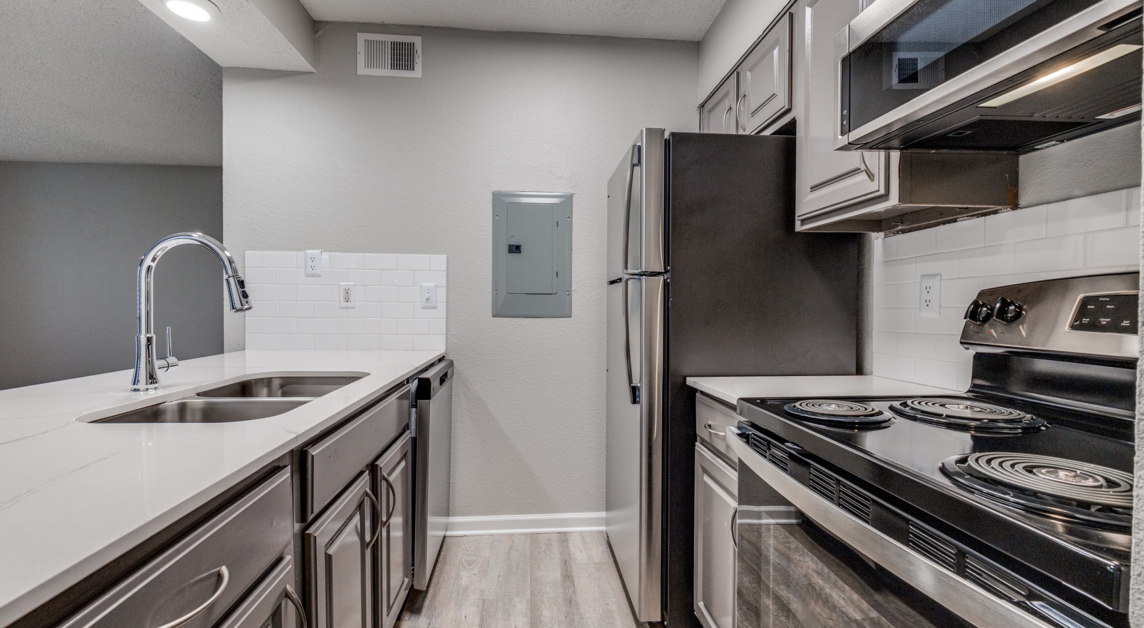 kitchen with stainless steel appliances and white cabinets at The Wilder