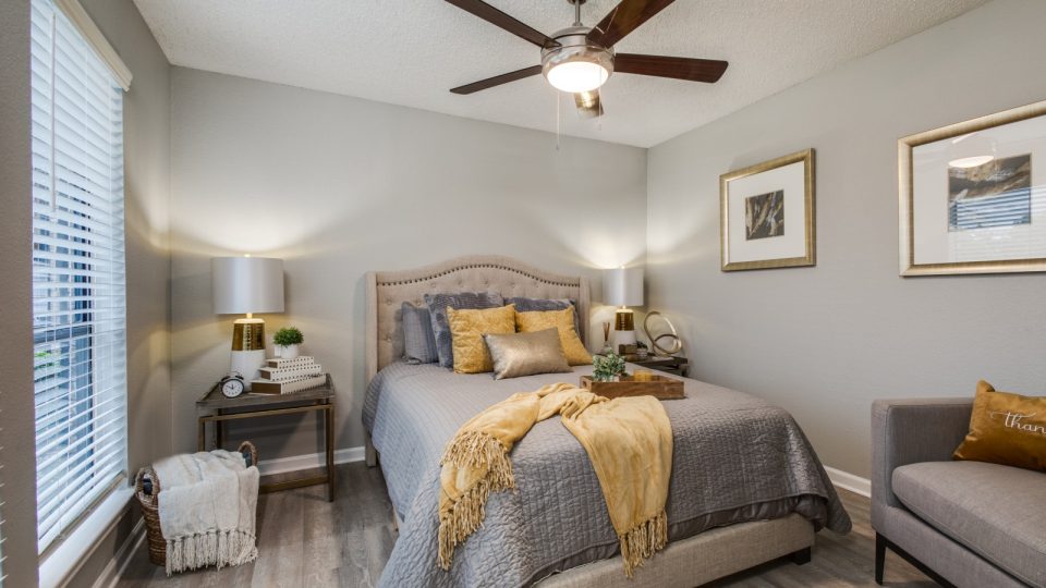 a bedroom with a bed, dresser and ceiling fan at The Wilder