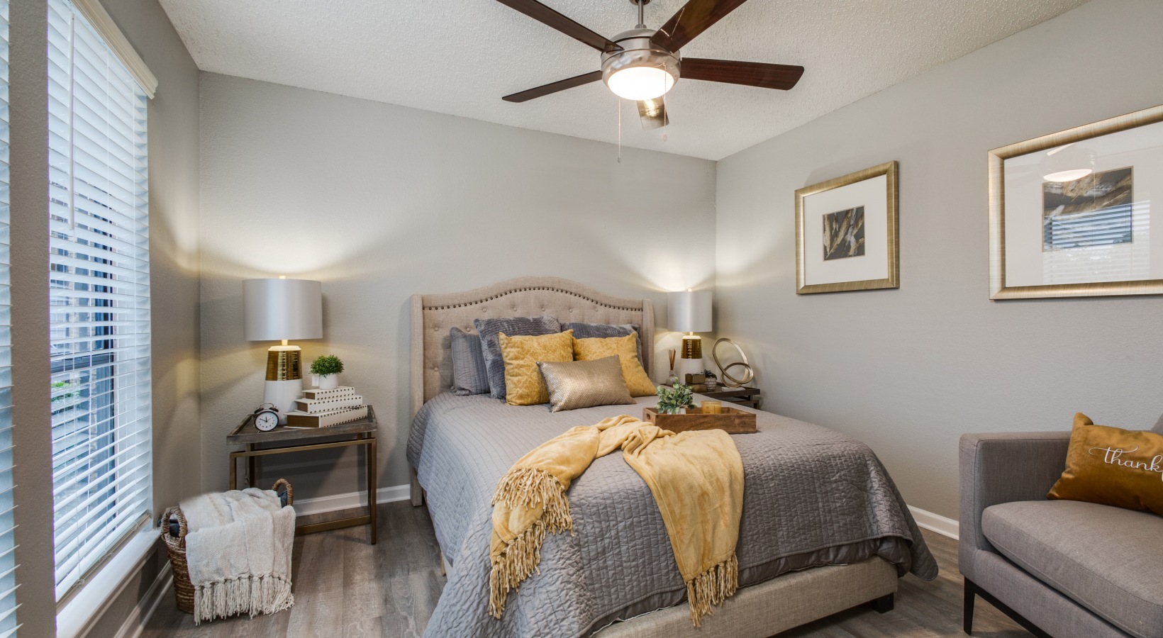 a bedroom with a bed, dresser and ceiling fan at The Wilder