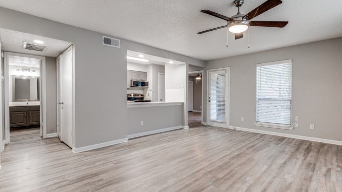 empty living room with ceiling fan and hardwood floors at The Wilder