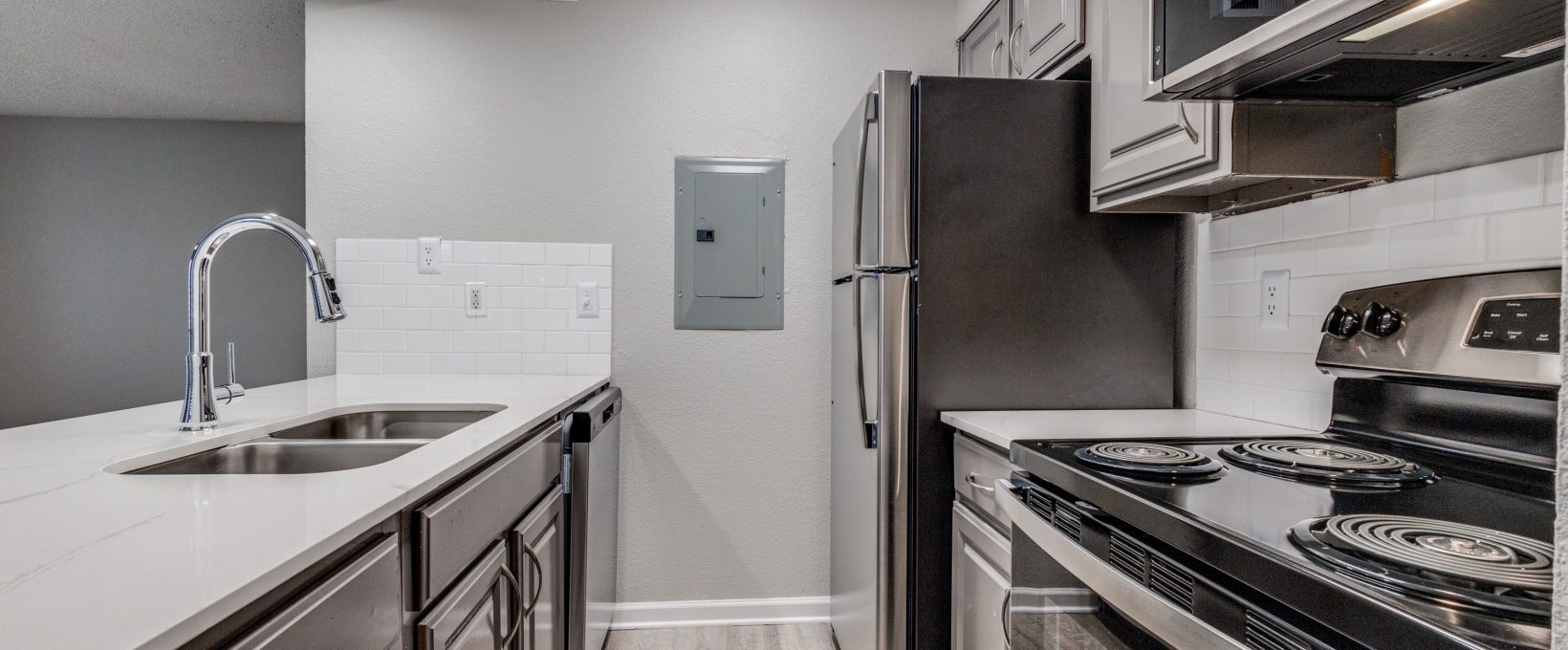 kitchen with stainless steel appliances and white cabinets at The Wilder