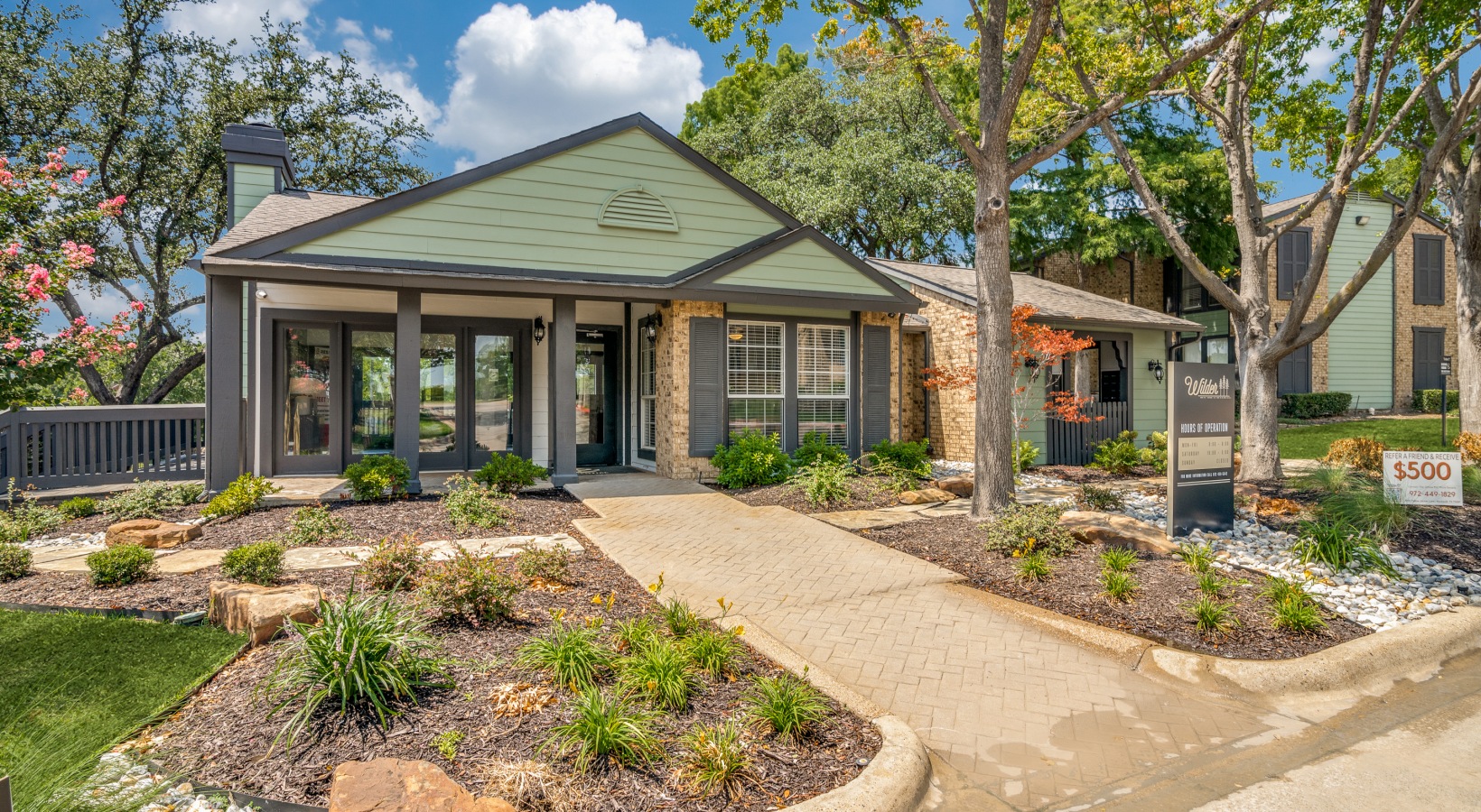 the front of a home with landscaping and trees at The Wilder